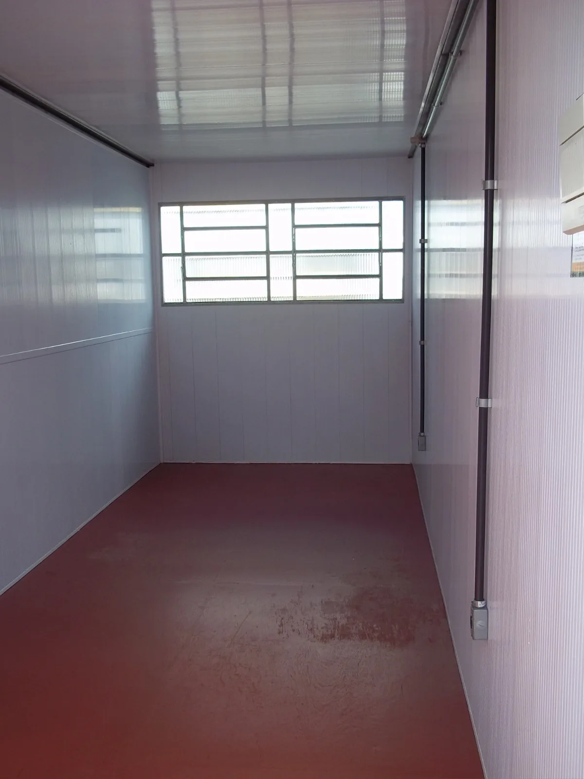 Interior de container escritório com janela e instalação elétrica